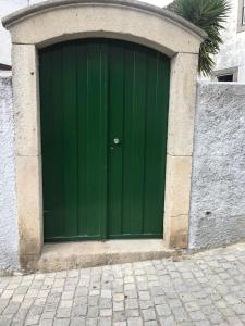 a green door in a building with a stone wall at Casa do Peso 1 in Peso da Régua