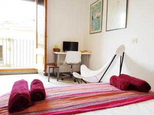 ein Schlafzimmer mit einem Bett, einem Stuhl und einem Schreibtisch in der Unterkunft Loft Plaça Sant Josep in Girona