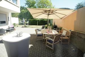 eine Terrasse mit einem Tisch und einem Sonnenschirm in der Unterkunft Ferienwohnungen Christina in Traben-Trarbach