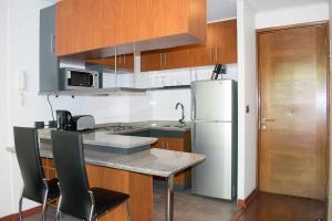cocina con nevera, mesa y sillas en Bellavista Spotlight Apartment, en Santiago