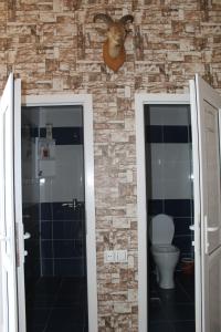 a bathroom with a toilet and a goat head on the wall at Ismayilli Guest House in İsmayıllı