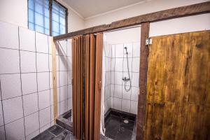 a bathroom with a shower with a wooden door at Hostal Licanantay in Valparaíso +47 photos