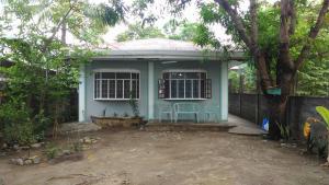 a small blue house with a chair in front of it at San Fabian Vacation Home in Mabilao