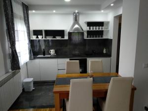 a dining room table with chairs and a kitchen at Villa Lucija in Poljanak