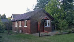 ヴェンディッシュ・リーツにあるFerienhaus Eschenalleeの庭の赤い扉のある小さな茶色の家