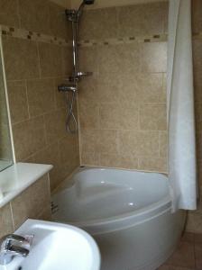 y baño con bañera, aseo y lavamanos. en Wheatlands Lodge Hotel en York