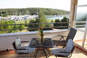 a balcony with chairs and a table and a view of a harbor at Apartman Studio in Pula