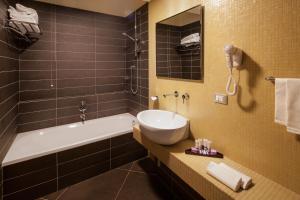 a bathroom with a tub and a sink and a bath tub at Hotel Da Vinci in Milan
