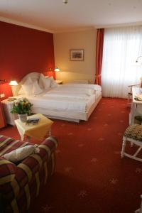 a hotel room with a large bed and a couch at Der Fischländer Garni in Ahrenshoop