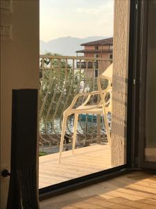 einen weißen Stuhl auf einem Balkon mit Aussicht in der Unterkunft Suite La Castellana in Torri del Benaco