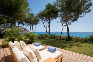 a white couch sitting on a wooden deck with the ocean at Can Simoneta - Adults Only in Canyamel