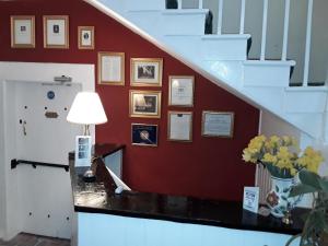 uma escada com uma mesa com um candeeiro e quadros na parede em Lowbyer Manor Country House em Alston