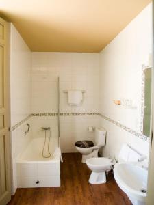 a white toilet sitting next to a bath tub in a bathroom at Hotel Roma in La Granja de San Ildefonso
