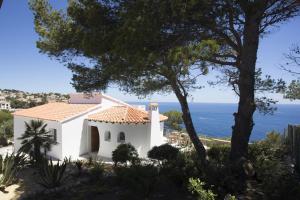a white house with the ocean in the background at Blue Dream Villa in Jávea