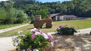 a garden with flowers and a statue in the grass at Agriturismo Fattoria Dalcastagnè in Torcegno