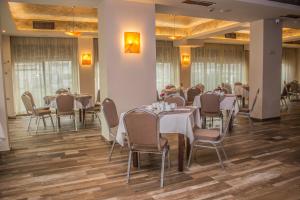 una sala da pranzo con tavoli e sedie in una stanza di Hotel Golden Tulip Varna a Varna