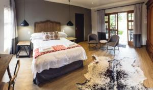 a bedroom with a large bed with a rug on the floor at Villiera Guesthouse in Douglas