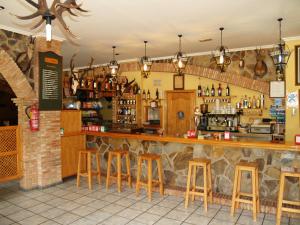 um bar num restaurante com bancos de madeira em Casa Guillermo em Arroyo Frío