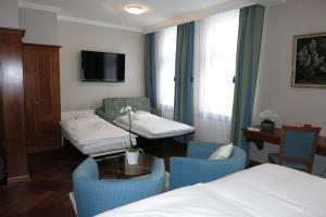 アッペンツェルにあるホテル ヘヒト アッペンツェルのベッド2台、テーブルと椅子が備わるホテルルームです。