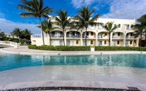 a hotel with a swimming pool in front of a building at Dreams Tulum Resort & Spa in Tulum