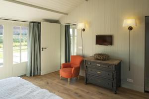 1 dormitorio con cama, silla y vestidor en Dromen in Drempt, en Drempt