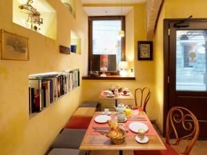 uma sala de jantar com duas mesas e uma estante de livros em Boutique Hotel Albero Nascosto em Trieste