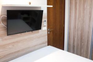 a room with a tv on a wall with a bed at Pipas Ocean in Pipa