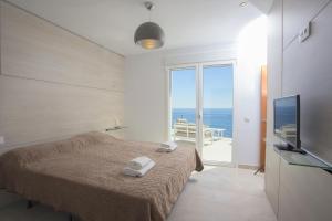 a bedroom with a bed and a television and the ocean at Blue Dream Villa in Jávea +32 photos