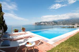 a swimming pool with a view of the water at Villa El Horizonte infinite pool in La Herradura