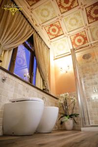 ein Badezimmer mit einem WC und einem großen Spiegel in der Unterkunft Villa Floridiana in Anagni