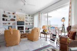 uma sala de estar cheia de mobiliário e uma grande janela em Villa El Horizonte infinite pool em La Herradura