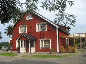 a red house with white windows and a porch at Yli-Kaitala Holiday Resort Tuuliviiri in Savio
