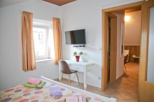 a bedroom with a bed and a desk and a tv at Guesthouse Anita in Kotor