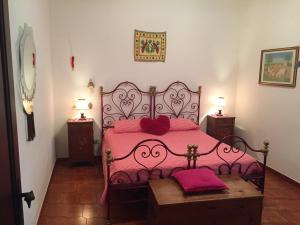 a bedroom with a bed with pink sheets and pink pillows at Villa Maria in Zafferana Etnea +51 photos