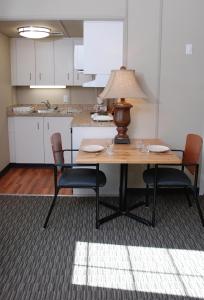 uma cozinha com uma mesa com cadeiras e um candeeiro em Triple J Hotel em Dawson City