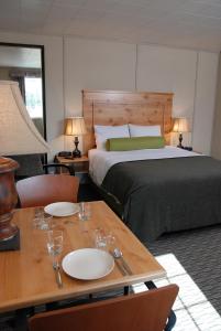Un dormitorio con una cama y una mesa con platos. en Triple J Hotel, en Dawson City
