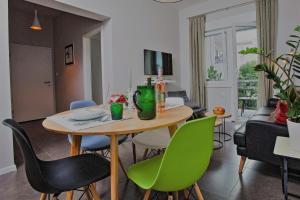 a living room with a table and green chairs at apartman ami in Split