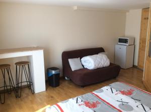 a living room with a couch and a microwave at Chambre d hôtes du lac in Echallon