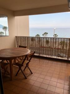 カンヌにあるBord de Mer Cannes Midiの海の景色を望む客室で、テーブルと椅子が備わります。