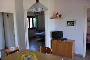 a living room with a table and a tv on a cabinet at Residence Belvedere in Capoliveri