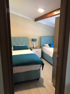 a bedroom with two beds with blue accents at Uzungol Comfort Residence in Uzungöl