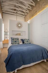 een slaapkamer met een groot bed en een blauwe deken bij Casa Poeta Cordobés Ricardo Molina in Córdoba