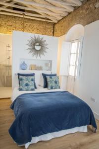 a bedroom with a bed with blue sheets and a mirror at Casa Poeta Cordobés Ricardo Molina in Córdoba