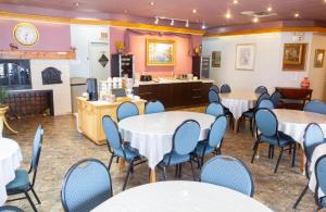 Auberge La Rocaille في شاوينيجان: غرفة بها طاولات وكراسي وطاولة