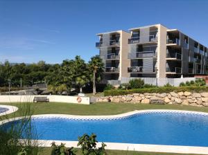 an apartment building with a swimming pool in front of a building at Paradise Village in Salou