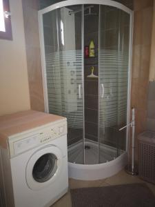 a washing machine in a bathroom with a shower at P'tite Case in Mornas