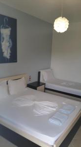 uma grande cama branca num quarto com luz em Guest House Solive em Himare