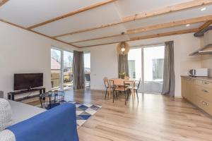 a kitchen and living room with a table and chairs at Atsipūskit in Palanga