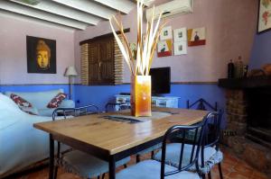 un comedor con una mesa con un jarrón. en Casas Rurales Lagunas de Ruidera - Piscina, en Ossa de Montiel