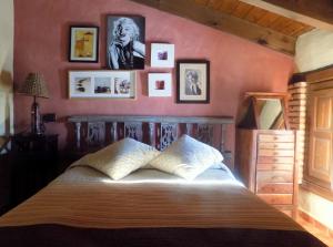 1 dormitorio con 1 cama con cuadros en la pared en Casas Rurales Lagunas de Ruidera - Piscina, en Ossa de Montiel 37 fotos más